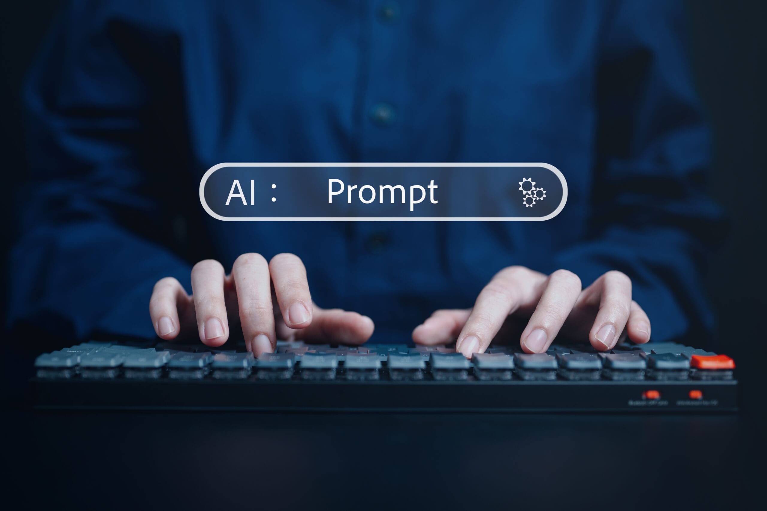 Person tippt auf einer Tastatur mit einer AI-Aufforderung auf dem Bildschirm, die den Einsatz von künstlicher Intelligenz in interaktiver Technologie darstellt.