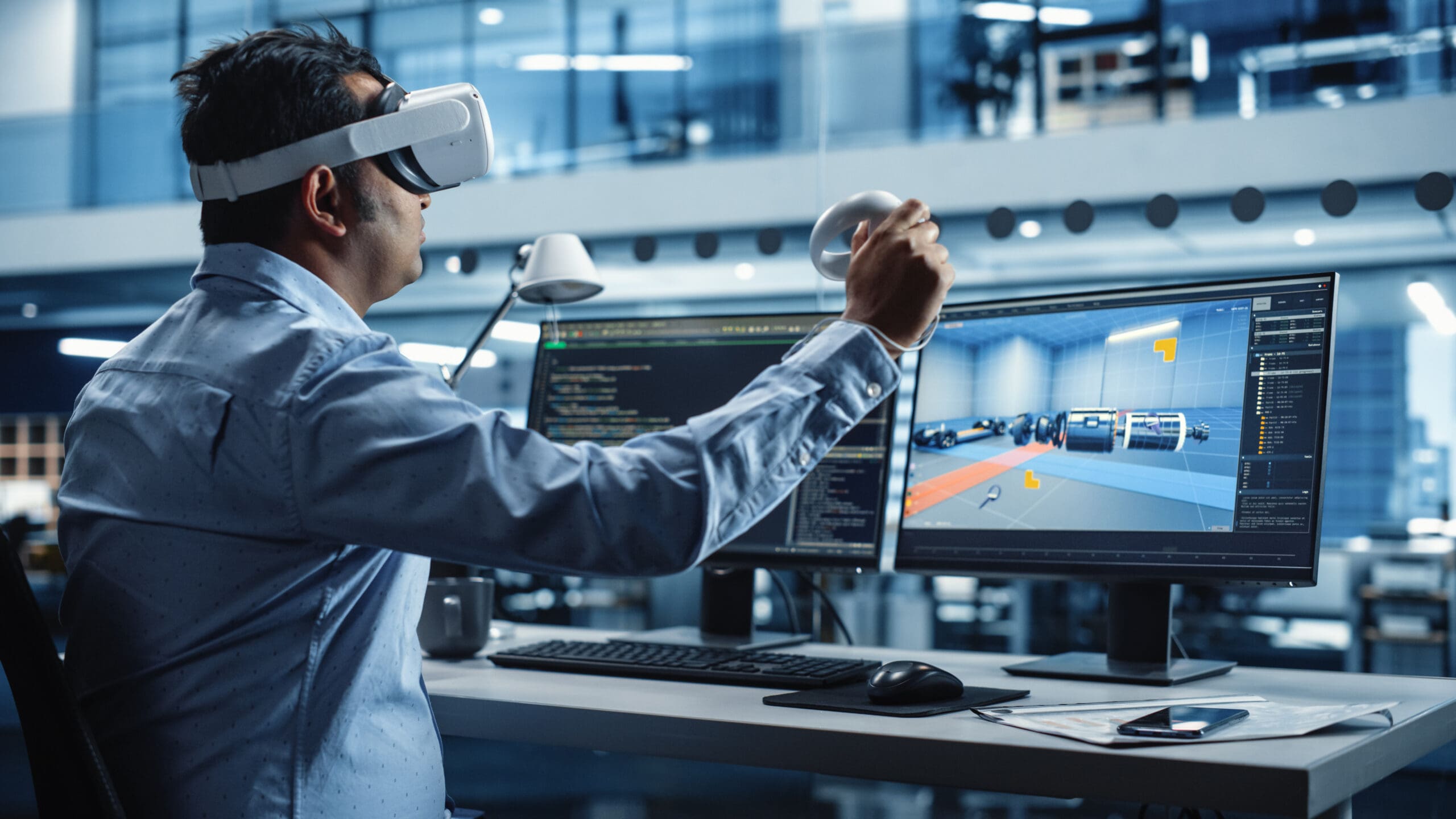 Entwickler verwendet VR-Headset und Controller zur Interaktion mit dem digitalen Zwilling eines Fahrzeugs auf einem Computerbildschirm.